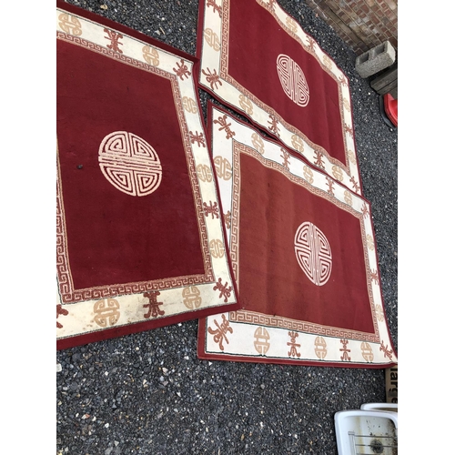 33 - A pair of large red Chinese rugs together with a matching small rug