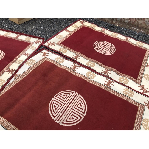 33 - A pair of large red Chinese rugs together with a matching small rug