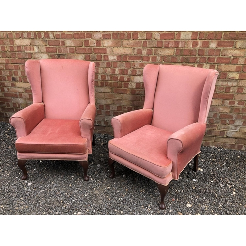 41 - A pair of pink upholstered wing armchairs