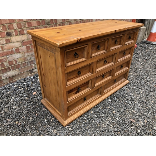 92 - A solid pine bank of 12 drawers with iron drop handles 122x49x84