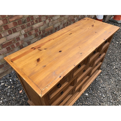 92 - A solid pine bank of 12 drawers with iron drop handles 122x49x84