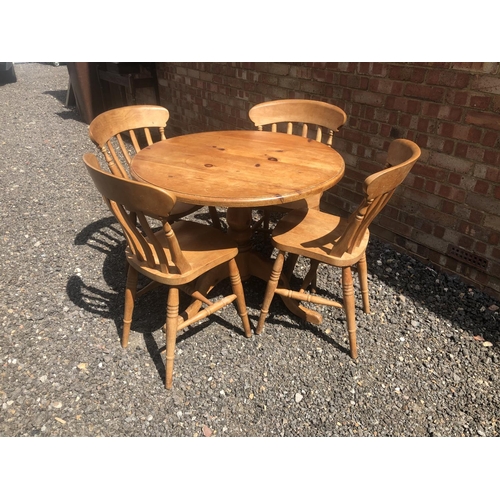 97 - A circular pine kitchen table 90cm diameter together with four pine Windsor chairs