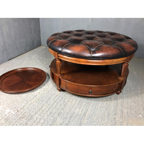 39 - A brown leather Chesterfield centre table / ottoman housing two drawers, together with matching drin... 