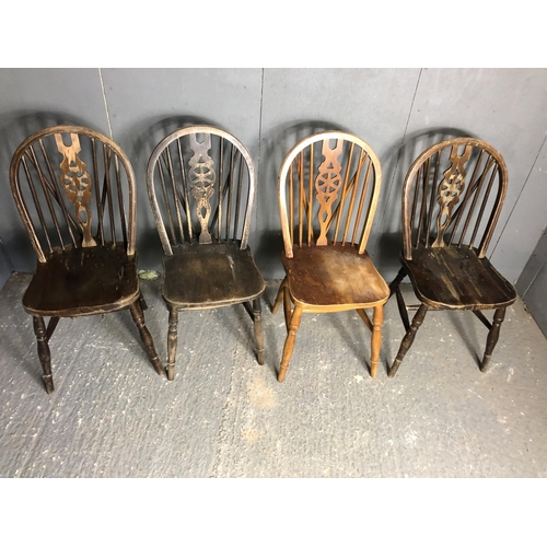 73 - A set of four wheelback dining chairs