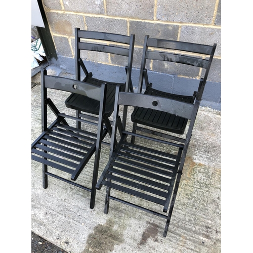 101 - A set of four black folding chairs