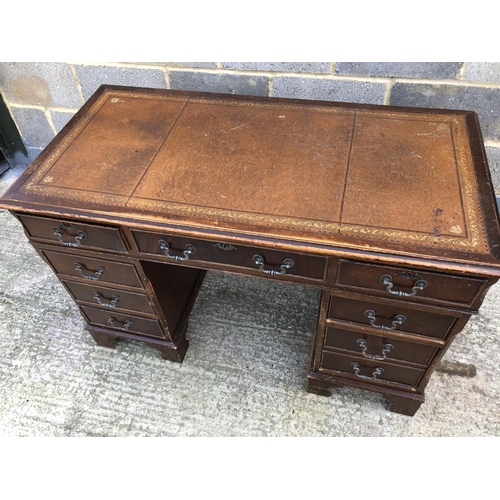 116 - A reproduction mahogany pedestal desk with a brown leather top