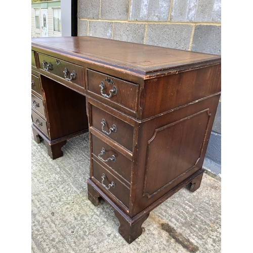 116 - A reproduction mahogany pedestal desk with a brown leather top