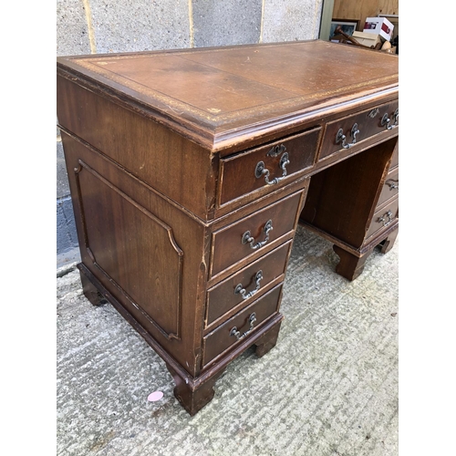 116 - A reproduction mahogany pedestal desk with a brown leather top