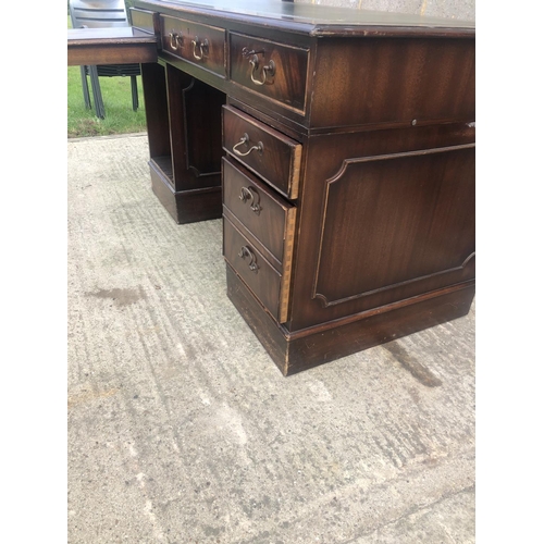 118 - A reproduction mahogany corner desk with green leather top  (AF)