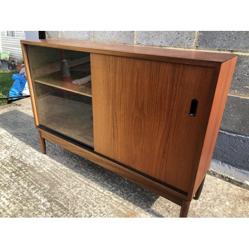 133 - A 1970's teak bookcase with sliding doors 105x28x74