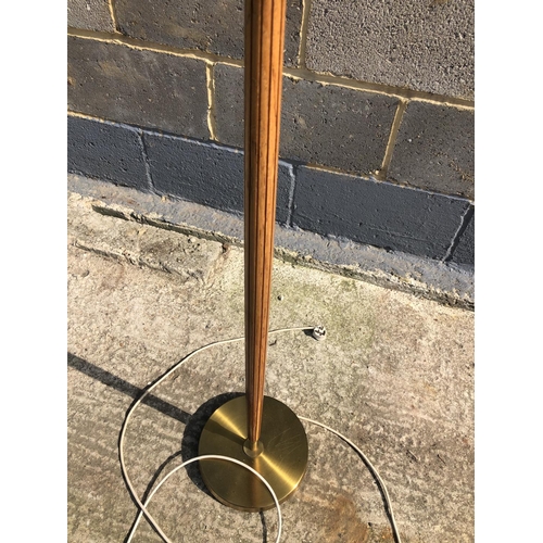 139 - A mid century teak standard lamp and shade on a brass base