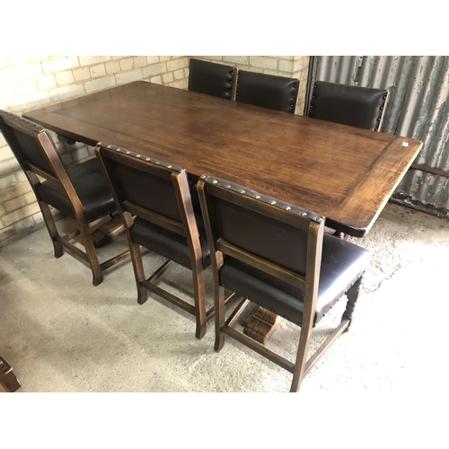 151 - An oak refectory dining table together with a set of six studded brown leather chairs by Jaycee