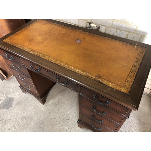 153 - A reproduction mahogany pedestal desk with a brown leather top