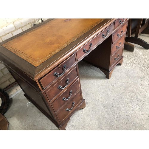 153 - A reproduction mahogany pedestal desk with a brown leather top