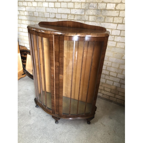 155 - A bow fronted walnut display cabinet with glass adjustable shelves