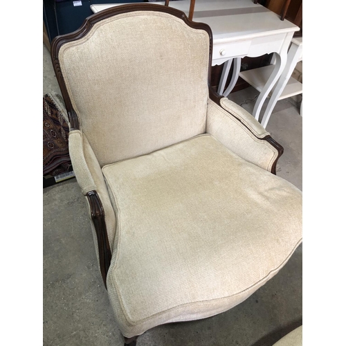 161 - A large cream upholstered beige French style armchair with footstool