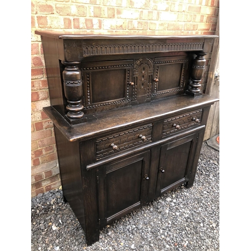 177 - A large oak court cupboard with upper drinks compartment over a two drawer and two door base