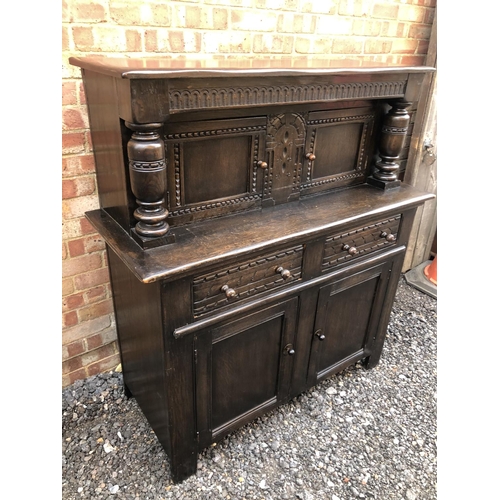 177 - A large oak court cupboard with upper drinks compartment over a two drawer and two door base