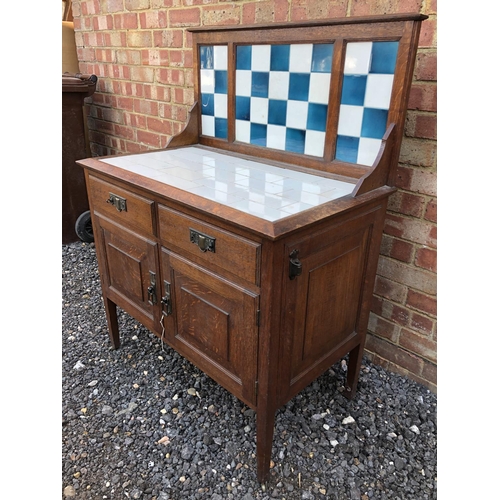 2 - A 20th century oak washstand with tiled rop and splash back 85x50x115