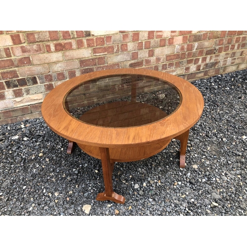 204 - A circular teak coffee table with a smoked glass drop in top 85cm diameter