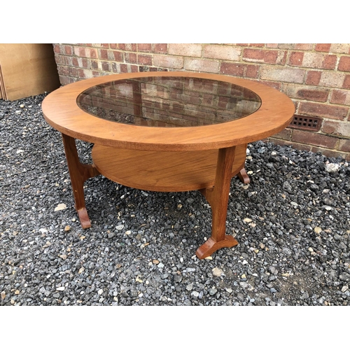 204 - A circular teak coffee table with a smoked glass drop in top 85cm diameter