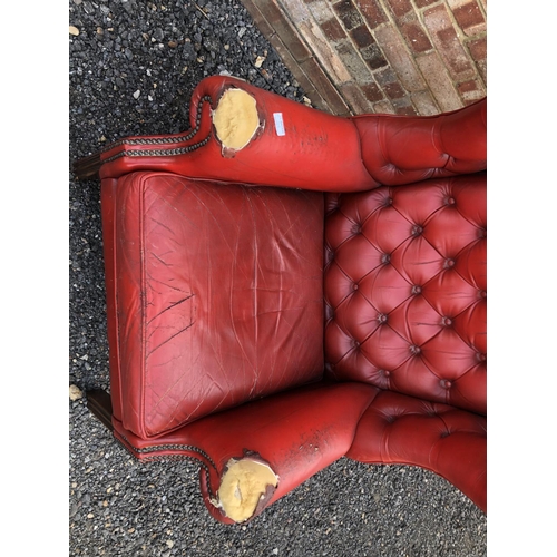 209 - A red leather Chesterfield wing chair (AF)