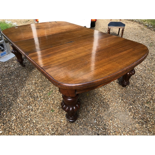 240 - A large Victorian oak wind out dining table with two extension leaves measures 276x142cm full extens... 