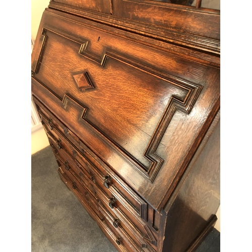 242 - An early 20th century oak bureau bookcase, a glazed cabinet top with three adjustable shelves over a... 