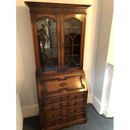 242 - An early 20th century oak bureau bookcase, a glazed cabinet top with three adjustable shelves over a... 