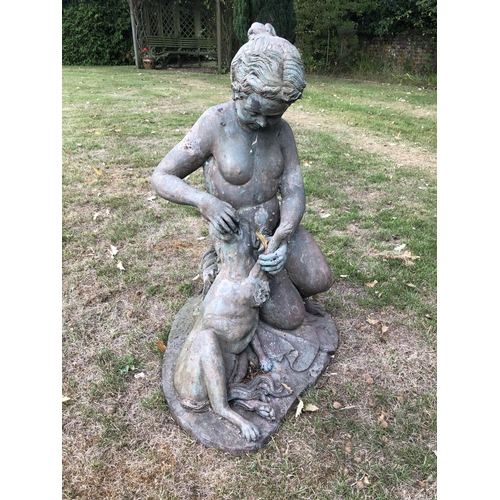 266 - A hollow cast bronze garden statue of a lady feeding a spaniel dog 80cm high