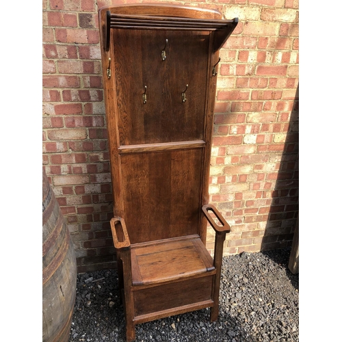 284 - A early 20th century oak hall seat mounted with brass coat hooks