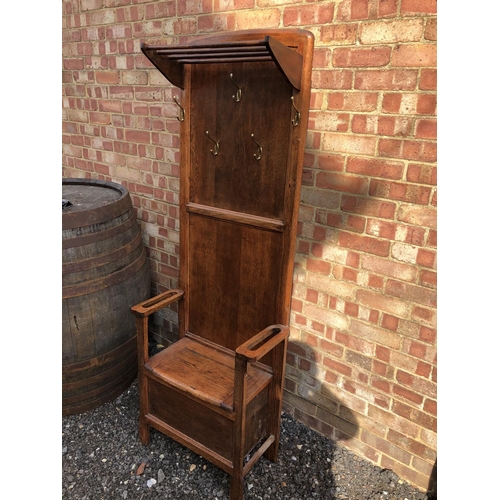 284 - A early 20th century oak hall seat mounted with brass coat hooks