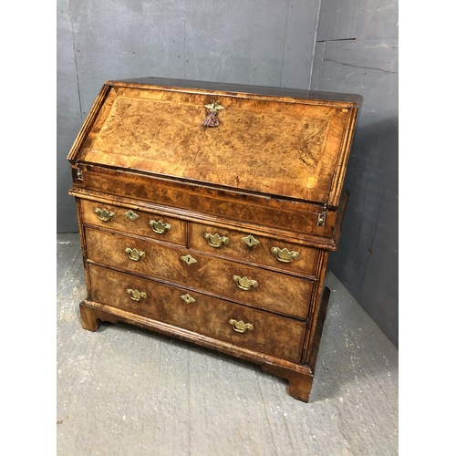 325 - A Georgian walnut bureau with a drop down front with a fitted interior above two short and two long ... 