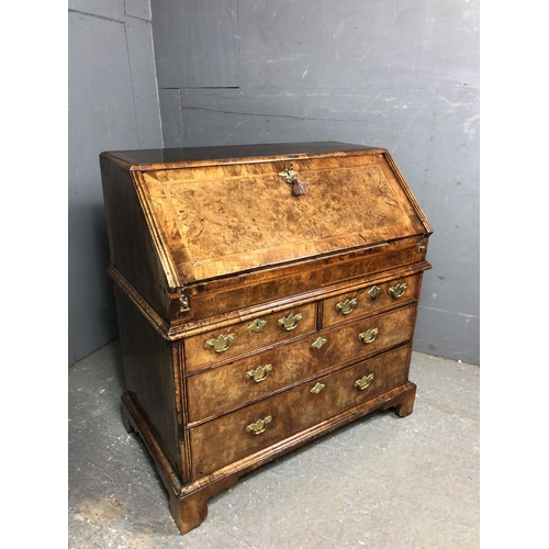 325 - A Georgian walnut bureau with a drop down front with a fitted interior above two short and two long ... 