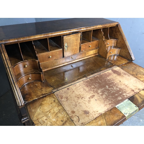 325 - A Georgian walnut bureau with a drop down front with a fitted interior above two short and two long ... 