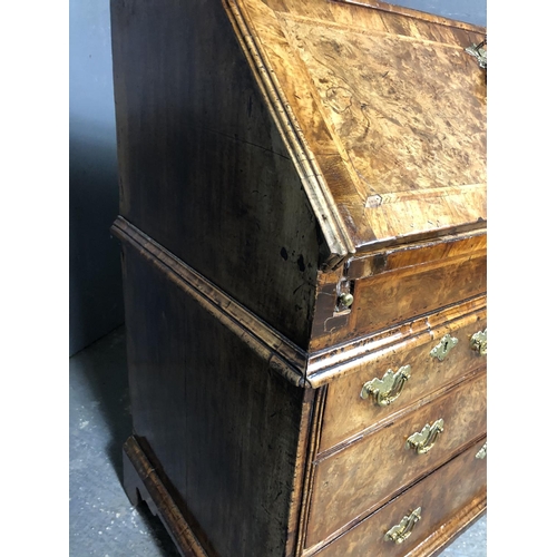 325 - A Georgian walnut bureau with a drop down front with a fitted interior above two short and two long ... 