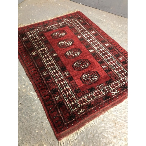 335 - A small red Patterned oriental rug 100x76