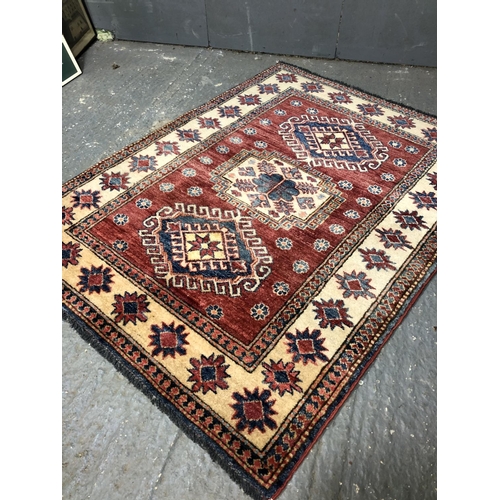 336 - A red and gold patterned rug 105x136