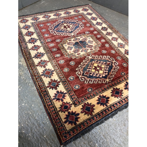 336 - A red and gold patterned rug 105x136