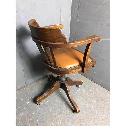 339 - A oak revolving desk chair with a tan brown seat