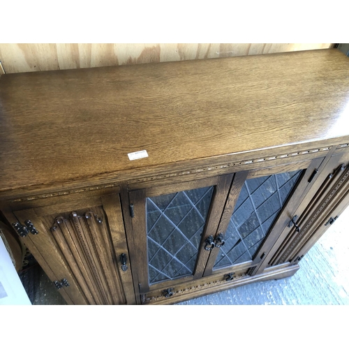 353 - A old charm style oak cabinet with leaded doors