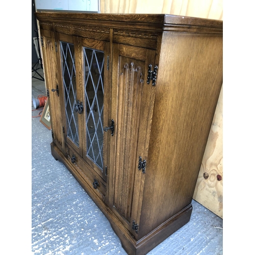 353 - A old charm style oak cabinet with leaded doors