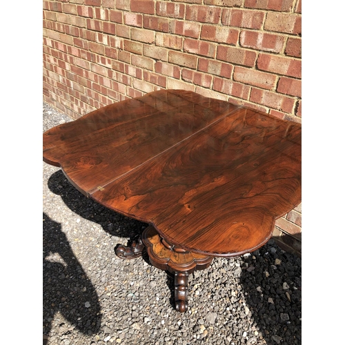 365 - A Victorian rosewood fold over tea table on a single bolster support