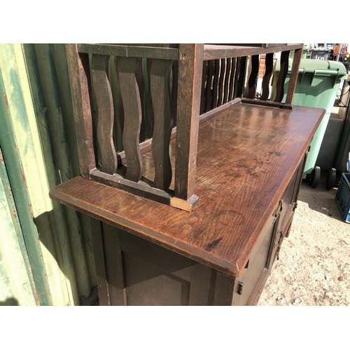 372 - An unusual Arts and crafts oak sideboard / dresser with long brass strap hinges and  brass drop hand... 