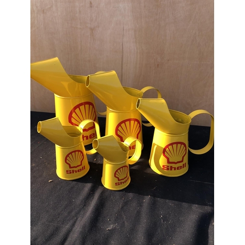 399 - A graduated set of five shell oil pouring jugs