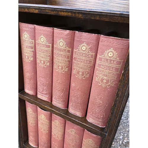 52 - A small oak bookcase containing a set of 15 Dickens books