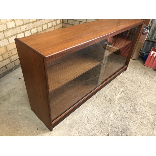 107 - A 1970's teak bookcase with two glass sliding doors 134x30x66