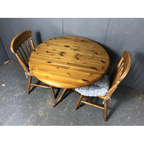 17 - A solid pine drop leaf table together with two chairs