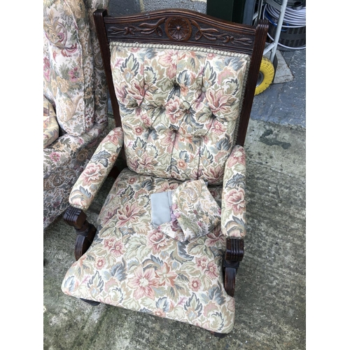 25 - An Edwardian button back armchair together with a modern fireside chair both upholstered in a floral... 