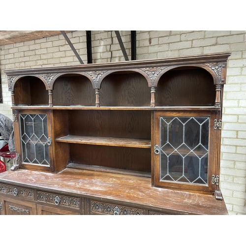 106 - An oak linen fold dresser with leaded glass panels 187x48x189